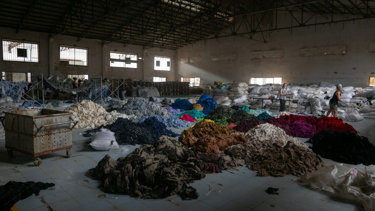 Bulk clothing being sorted in a warehouse